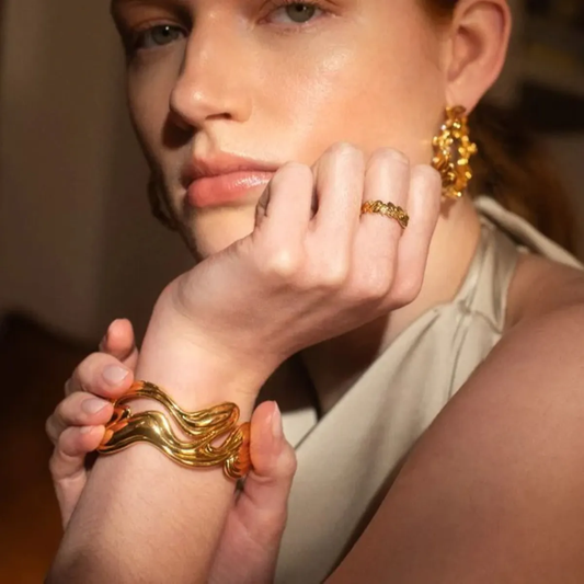 model wearing 18k gold-plated, stainless steel bangle cuff, ring and earrings. Waterproof and hypoallergenic.