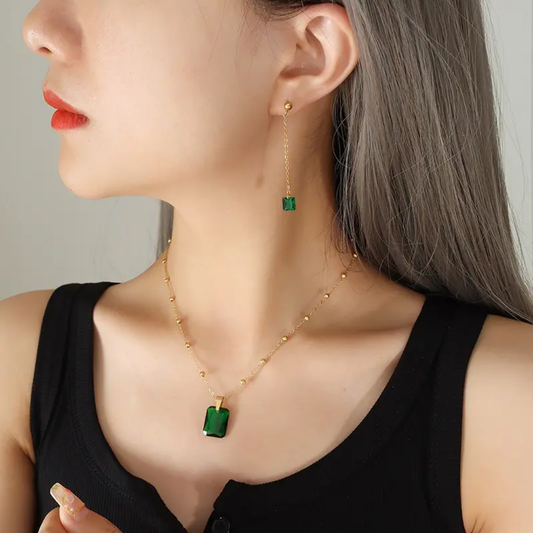 Model wearing TISA Emerald Icon set – elegant emerald zircon necklace and earrings for parties and special occasions, gold-plated and hypoallergenic