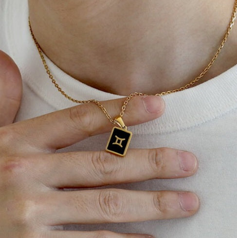 Model wearing TISA Zodiac Pendant Necklace – hypoallergenic 18k gold necklace with waterproof black onyx zodiac pendant.