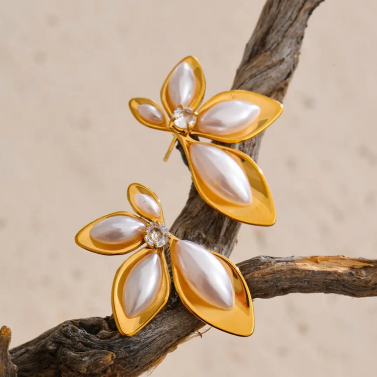 18k gold plated floral stud earrings with pearl inlay, petal design on textured branch background.