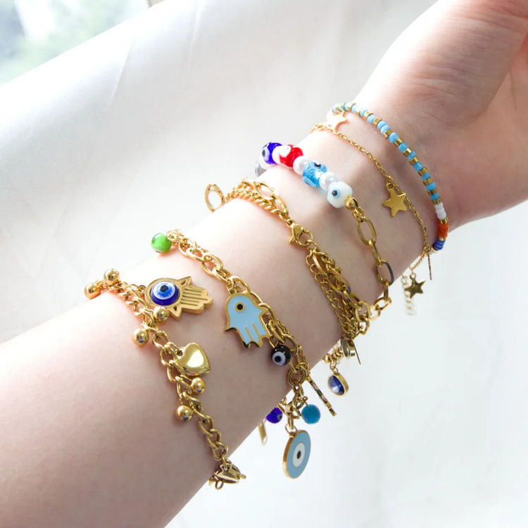 A collection of 18K gold-plated stainless steel bracelets, featuring Evil Eye, Hamsa Hand, chain link, and beaded Evil Eye designs. Anti-tarnish, hypoallergenic, and waterproof for lasting style