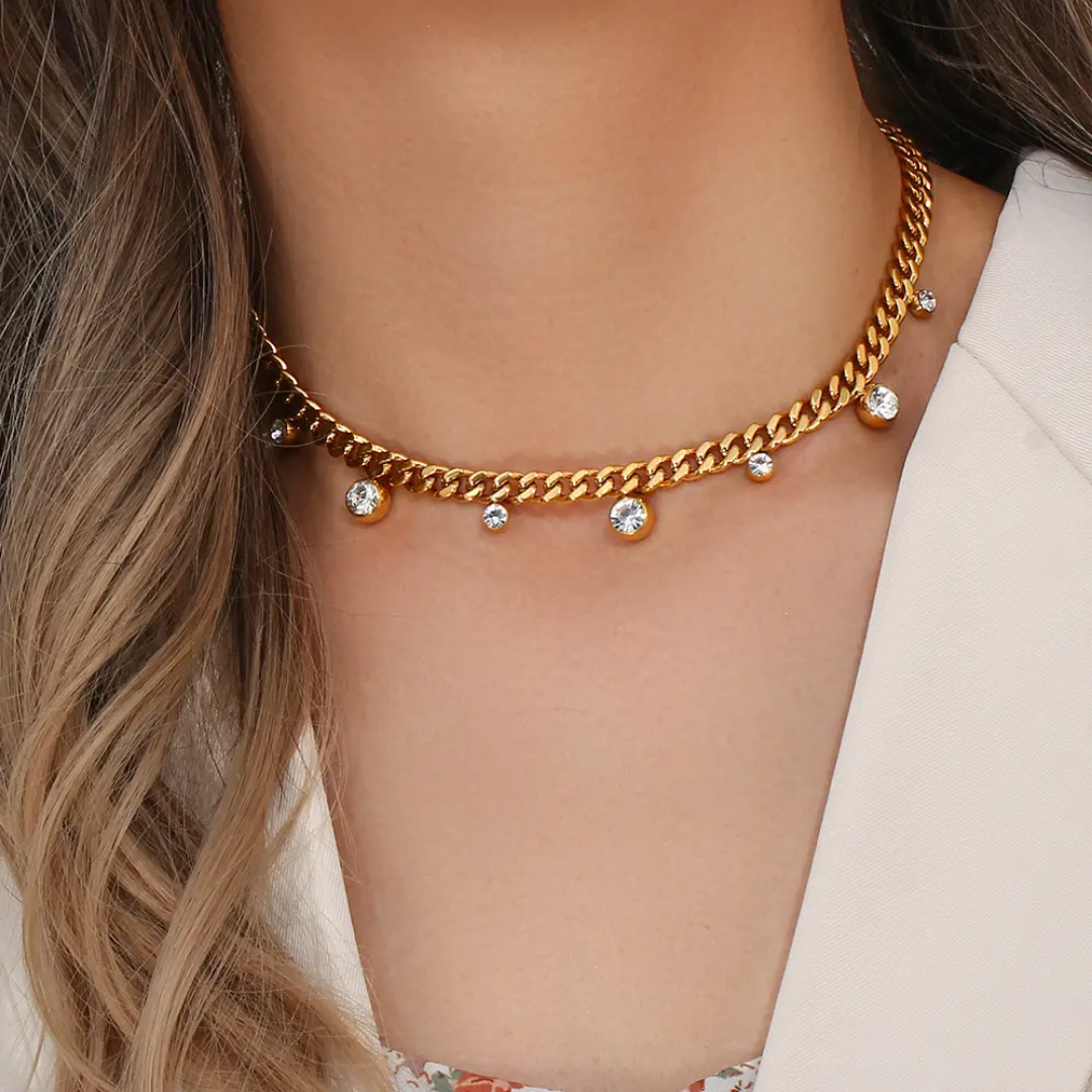 Model wearing TISA Cuban Chain Necklace with Zircon Charms – stylish waterproof 18K gold-plated necklace worn for party or evening look.
