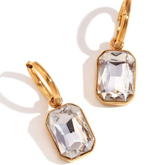 Gold-plated hoop earrings featuring clear rectangular crystal drops displayed on a white background.