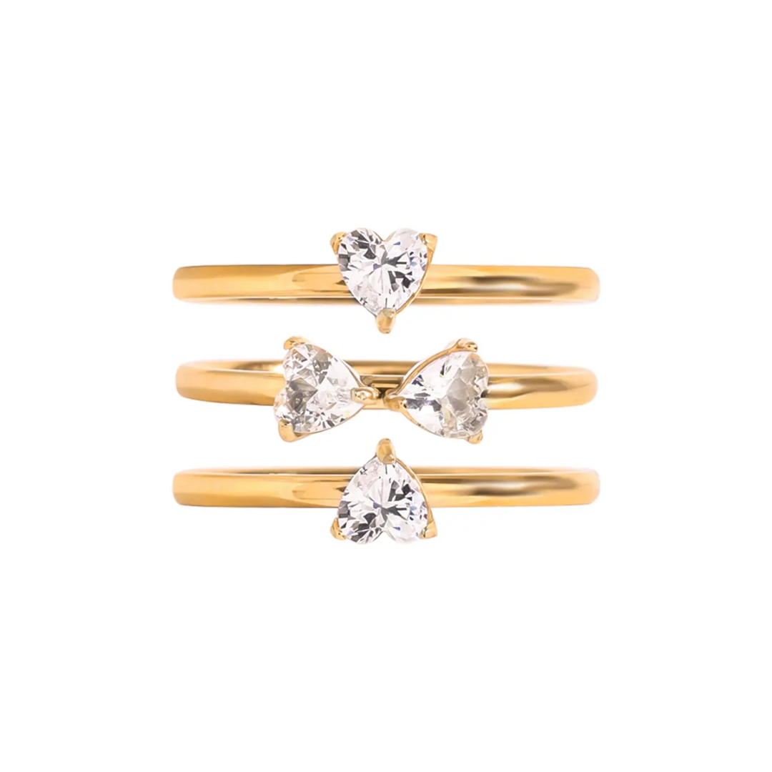 Tisa Set of three 18k gold plated rings with heart-shaped zircons on a white background