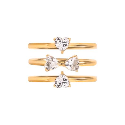 Tisa Set of three 18k gold plated rings with heart-shaped zircons on a white background