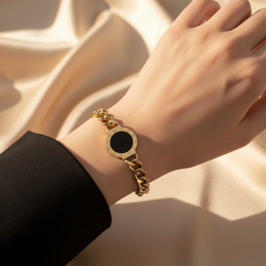 18k gold plated stainless steel bracelet with a black roman dial center on a wrist against a neutral background
