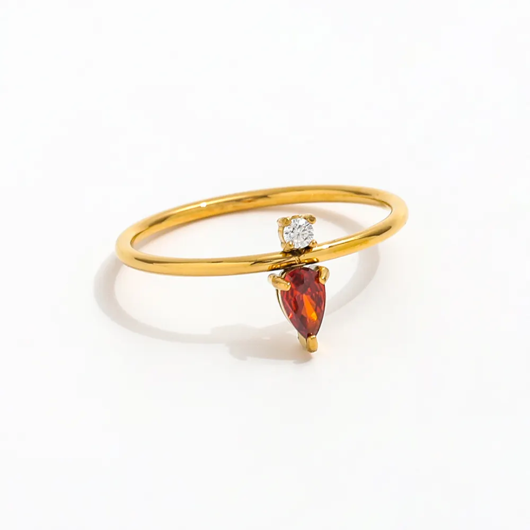 Tisa 18k Gold plated ring with a red  garnet gemstone and a small zircon on a white background.