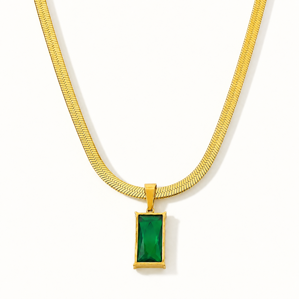 A Tisa 18k goldplated snake chain necklace with a rectangular green gemstone pendant, shown against a plain white background.