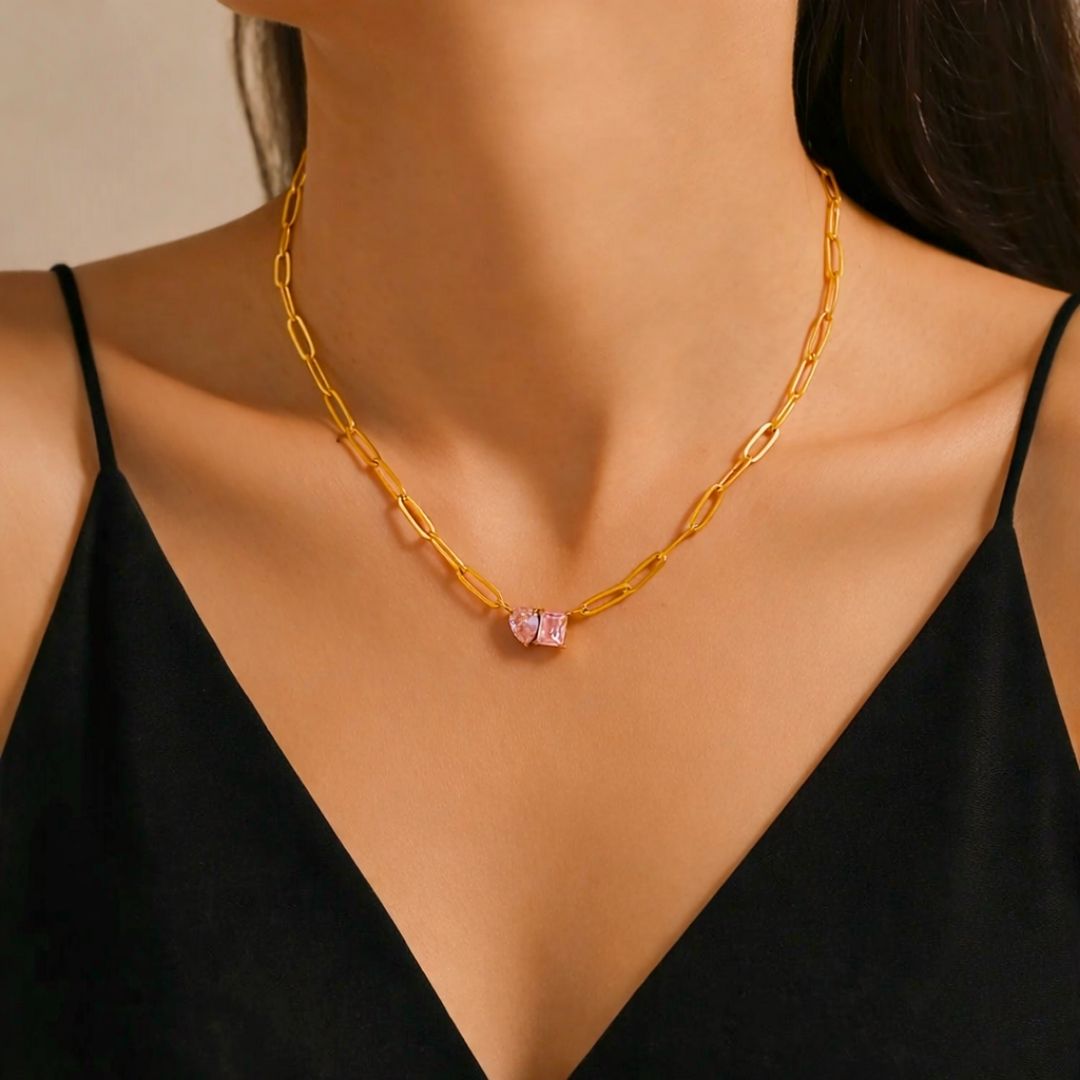 18k Gold plated chain necklace with a blush pink zircons worn by a model in a black top.