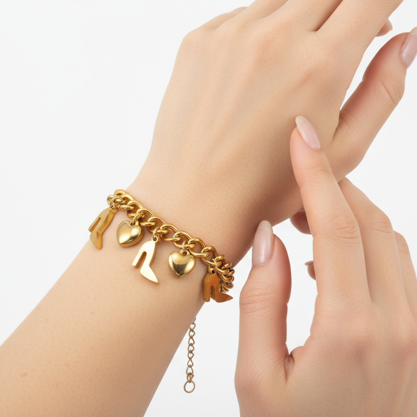 Model wearing Tisa's 18k gold plated charm bracelet against a neutral background.