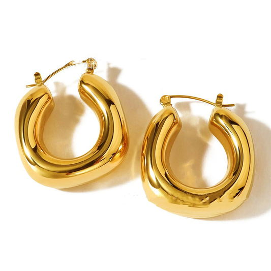 A pair of chunky, polished 18k gold plated hoop earrings with a curved, organic shape, displayed on a clean white background.