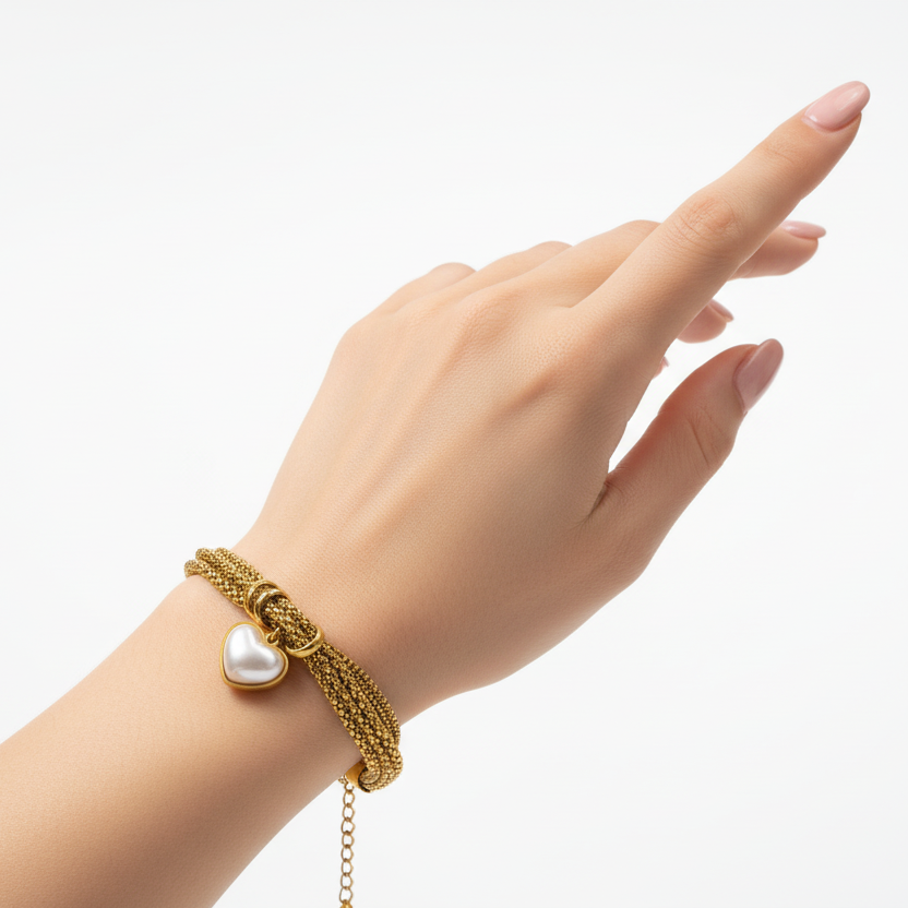 18k Gold plates bracelet with a heart-shaped charm on a hand against a white background