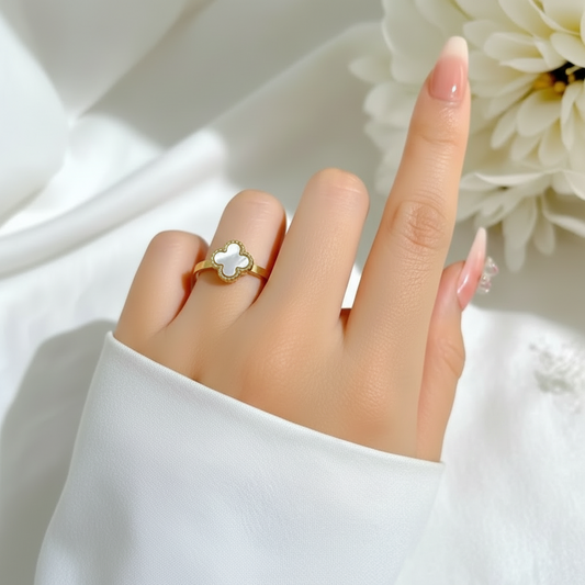 Hand wearing Tisa 18k gold plated clover ring on a white background