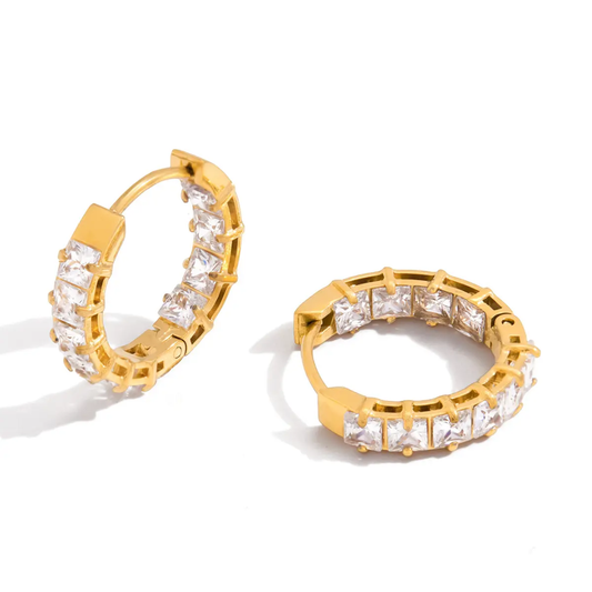 Gold hoop earrings with clear zircons on a white background