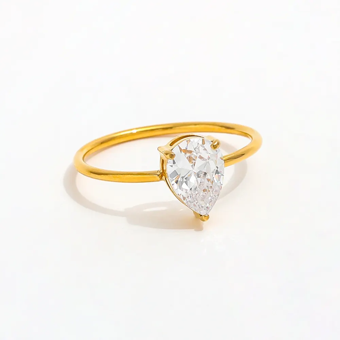 18k gold plated solitaire ring with a pear-shaped diamond on a white background. 