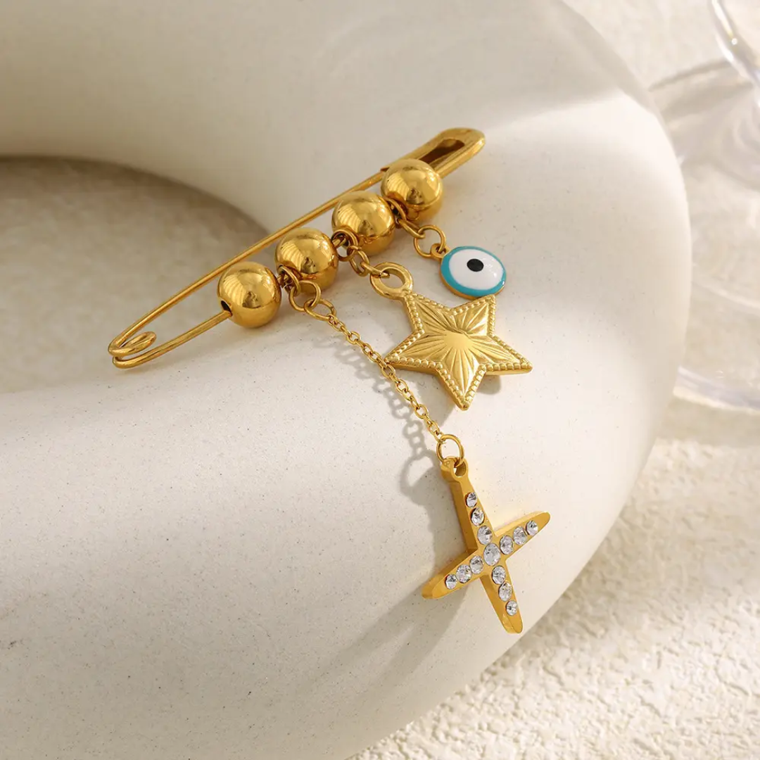 18k Gold plated brooch with star and eye design on a white surface