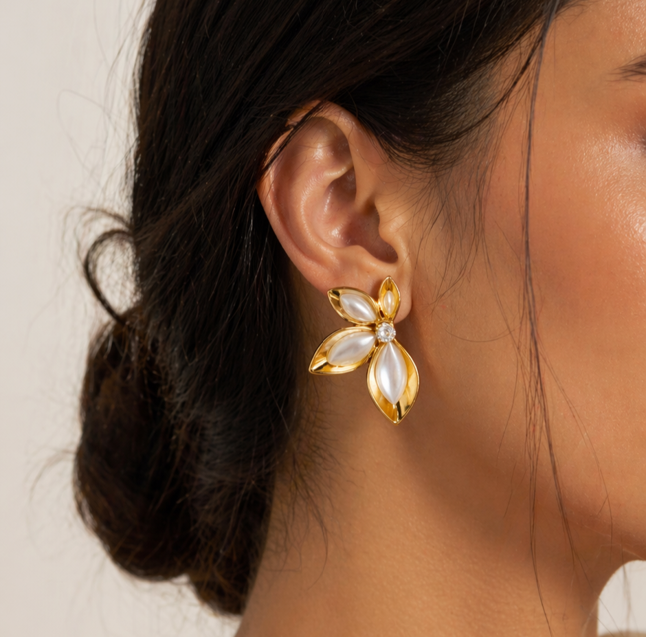 Close-up of model wearing Tisa 18k gold plated Golden Petal Studs earrings with a neutral background.