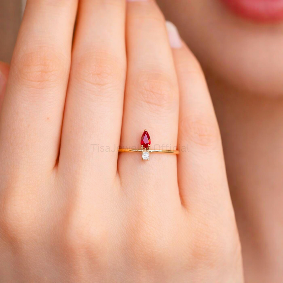 Model wearing Tisa 18k Gold plated ring with a red garnet gemstone and a zircon.