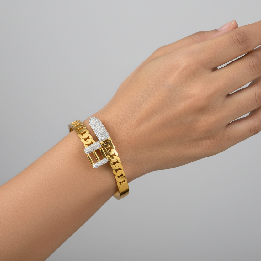 Model wearing a 18k gold plated bracelet on a wrist against a gray background